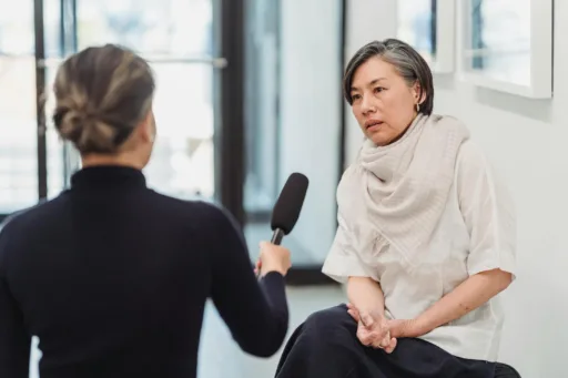 Professional interview setting with a female journalist and woman discussing indoors.